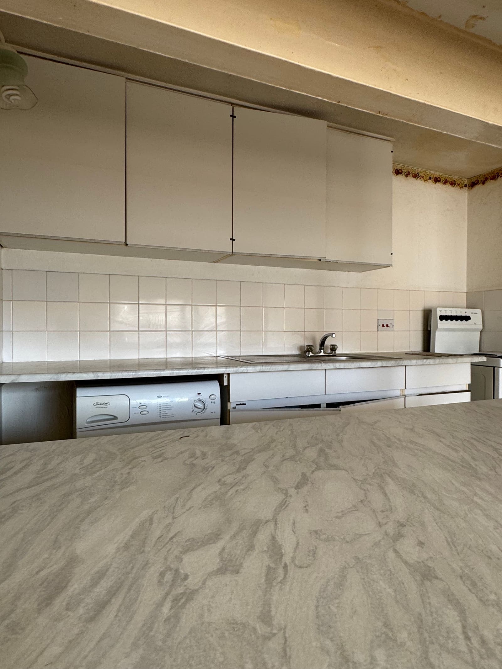 Tired white kitchen with freestanding appliances before refurbishment, Osprey House Hove