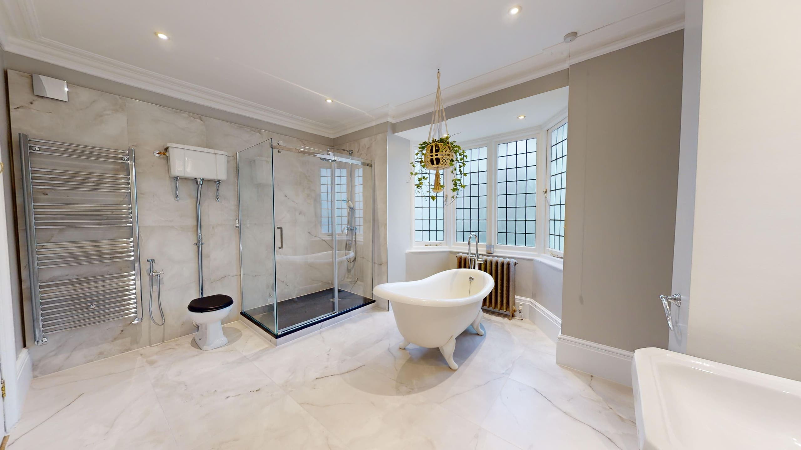 Period bathroom refurbishment with roll-top bath, chrome towel radiator and leaded bay windows, Western Road Brighton